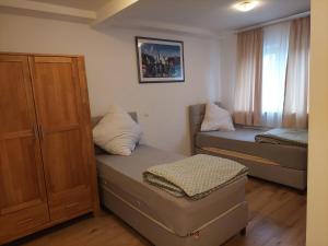 a small room with two beds and a cabinet at Hotel Bruchsal Herz in Bruchsal