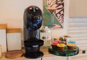 a black coffee maker on a counter with cupcakes at Otto Apartment Montecatini in Montecatini Terme