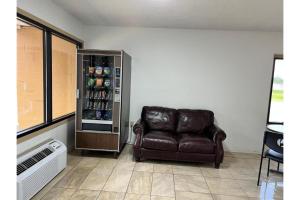 a brown leather chair in a room with a refrigerator at Devils Lake Inn By OYO Near Devils Lake Regional Airport in Devils Lake