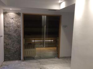 eine Glastür, die in ein Zimmer mit einem Stuhl führt in der Unterkunft Hotel Silvana in Wolkenstein in Gröden