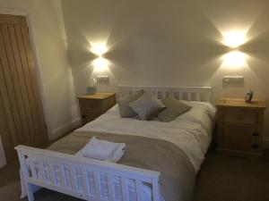 um quarto com uma cama branca com duas mesas de cabeceira em Three Crowns Guest House em Salisbury