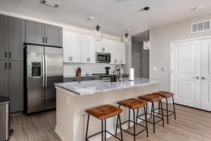 eine Küche mit einer großen Theke mit Hockern an einer Bar in der Unterkunft Charming, New Apt, Pool, Long Stays in Athens