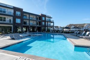 ein großes Schwimmbad mit Stühlen und einem Gebäude in der Unterkunft Charming, New Apt, Pool, Long Stays in Athens