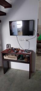 a table in a room with a television on a wall at Casa Ponte Branca em Paraty in Paraty