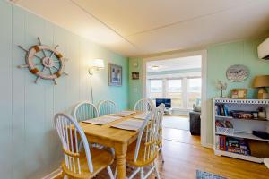 a dining room with a wooden table and chairs at The Eastern Avenue Cottage in Wells Beach