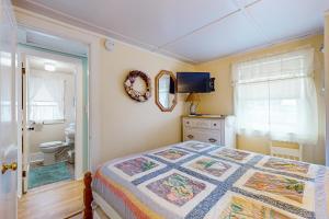 a bedroom with a bed and a bathroom at The Eastern Avenue Cottage in Wells Beach