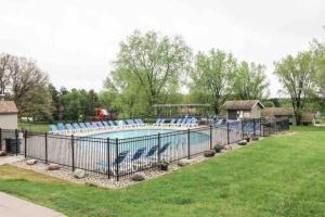 a swimming pool with blue chairs in a yard at Waterfront Boho Retreat in Wisconsin Dells