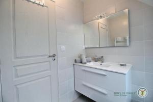 a white bathroom with a sink and a mirror at Togwenn in Trélévern +28 photos
