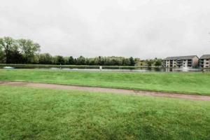 a field of grass with a building in the background at Waterfront Boho Retreat in Wisconsin Dells