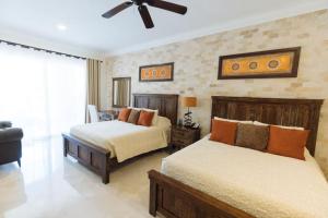 una camera da letto con due letti e un ventilatore a soffitto di Beachfront, Premium Ocean View, VLE 1305 a Cabo San Lucas Altre 20 foto