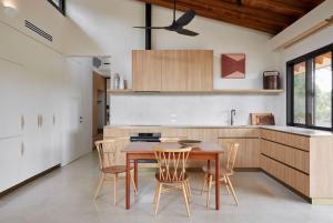 a kitchen with a wooden table and chairs at Ukiyo House The Floating World in Port Willunga