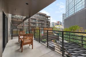 uma varanda com duas cadeiras e uma mesa num edifício em Luxury in The Gulch with Patio Pool Walk to Broadway em Nashville