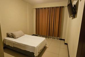 a small room with a bed and a television at Departamento Entero in Vallejos