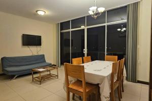 a dining room with a table and a blue couch at Departamento Entero in Vallejos