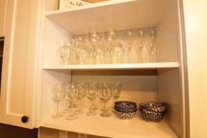 a cupboard filled with wine glasses and bowls at Waterfront Boho Retreat in Wisconsin Dells