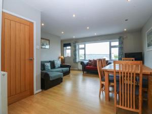 a kitchen and living room with a table and chairs at Ty Nant in Abersoch
