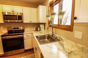 a kitchen with a sink and a microwave at Waterfront Boho Retreat in Wisconsin Dells +7 photos