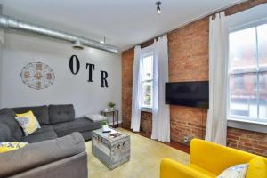 a living room with a couch and a brick wall at Walk to Everything - Sports, Food, Music, Downtown in Cincinnati