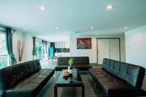 a living room with two leather couches and a table at Pandora in Ko Samed