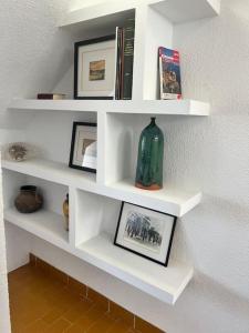 ein weißes Regal mit einer Vase und Bildern darauf in der Unterkunft La Pecera de Isla Plana in Isla Plana
