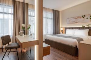 ハノイにあるKeypad Hotel - Linh Langのベッドと机があるホテルの部屋