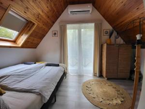 a bedroom with a bed and a large window at Kobra House in Orfű
