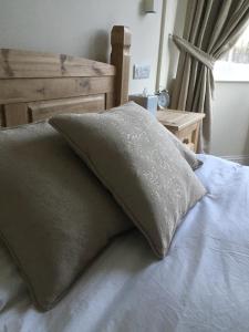 uma almofada sentada em cima de uma cama em Three Crowns Guest House em Salisbury
