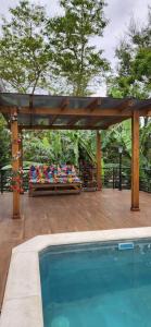 a pergola and a swimming pool next to a house at kit net em casa de família Florianópolis in Florianópolis