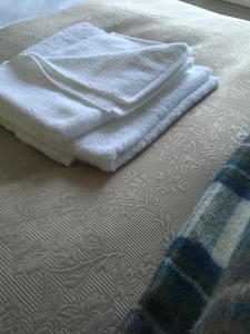 a pair of towels sitting on top of a bed at Three Crowns Guest House in Salisbury