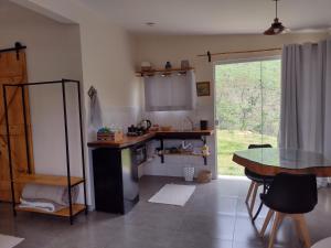 a kitchen with a table and a glass table at Reserva das Oliveiras in Nova Friburgo
