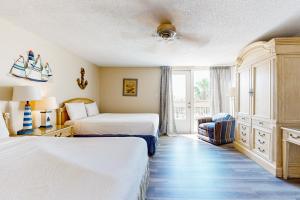 a hotel room with two beds and a chair at Solare Garden Villa #773 in South Padre Island +59 photos