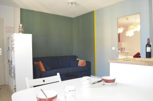 a living room with a blue couch and a table at Amélia in Soulac-sur-Mer