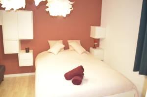 a bedroom with a bed with a shoe on it at Amélia in Soulac-sur-Mer +9 photos