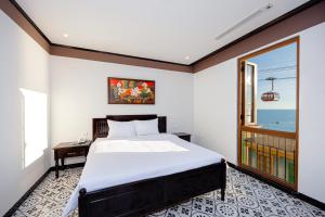 a bedroom with a large bed and a window at Thala Hotel Sorrento in Phu Quoc +38 photos