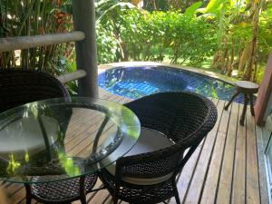 a table and chairs on a deck next to a pool at Villas Supreme Apartamentos in Maceió