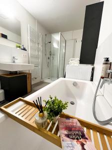a bathroom with a bath tub with a book on it at StayZen Holz & Hirsch Deluxe Hideaway zentral mit Parkplatz in Isny im Allgäu