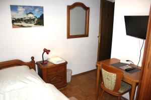 a bedroom with a bed and a desk and a mirror at Hotel Alte Münze in Gifhorn
