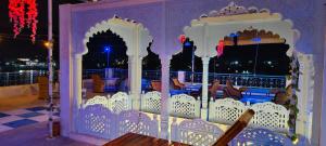 a white gate with a table on a balcony at night at Hotel Bharatpur Palace in Pushkar
