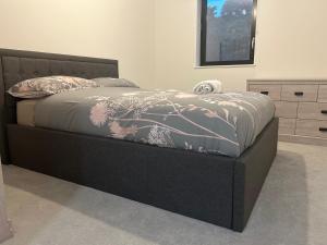 a bedroom with a bed with a black bed frame at Kinzo's Apartment in Chatham
