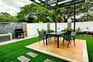 a patio with a table and chairs and a piano at Austin Leisurely villa in Johor Bahru