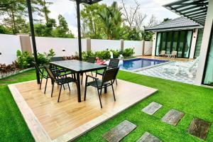 a patio with a table and chairs next to a swimming pool at Austin Leisurely villa in Johor Bahru