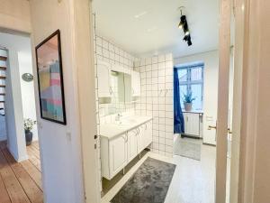 a white bathroom with a sink and a mirror at Spacious and modern house close to Århus Center in Aarhus +23 photos