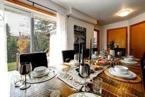 a dining room with a table and a large window at Le Alesund, 5BR avec SPA, PLAGE et embarcations in Sainte-Lucie-de-Doncaster