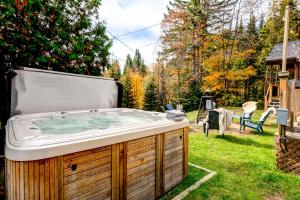 a hot tub in the backyard of a yard at Le Alesund, 5BR avec SPA, PLAGE et embarcations in Sainte-Lucie-de-Doncaster