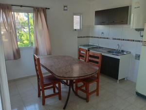a kitchen with a table and chairs and a sink at Departamentos Joaquin in Mar de Ajó