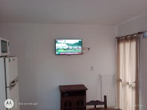 a flat screen tv hanging on a white wall at Departamentos Joaquin in Mar de Ajó