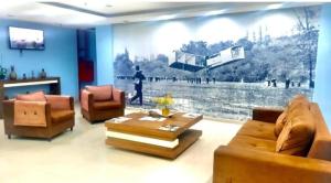 a living room with two couches and a large painting on the wall at Flats Via Mar in Macaé