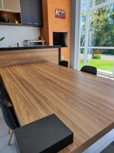 einen Holztisch in einer Küche mit einer Arbeitsplatte in der Unterkunft Casa de Campo Ninho Verde Eco Residence in Quadra + 5 Fotos