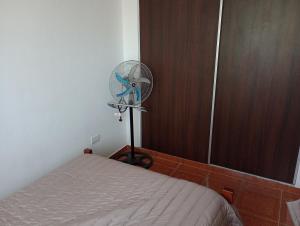 a room with a fan next to a bed at Departamentos Joaquin in Mar de Ajó