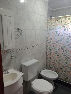 a bathroom with a toilet and a sink at Departamentos Joaquin in Mar de Ajó